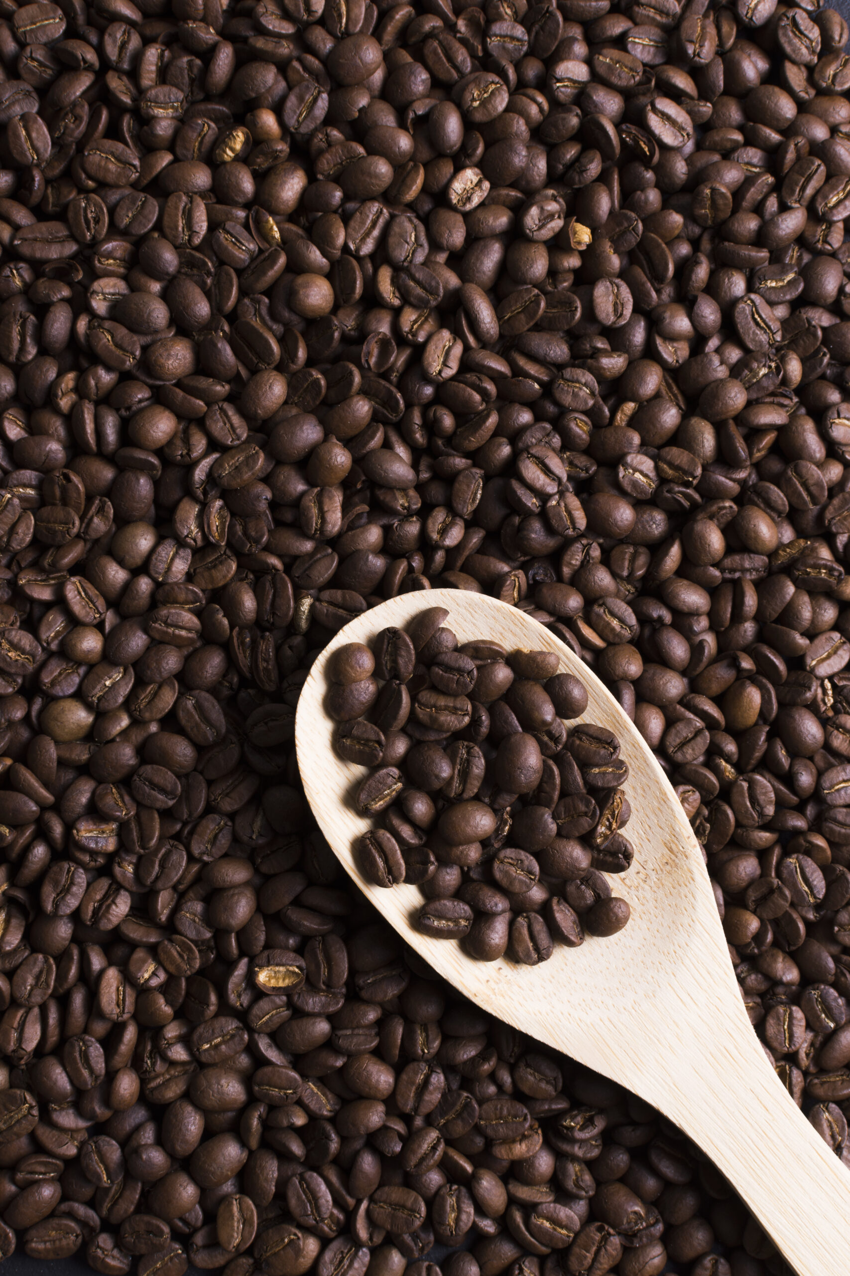 roasted-beans-tasteful-coffee-top-view-with-wooden-spoon