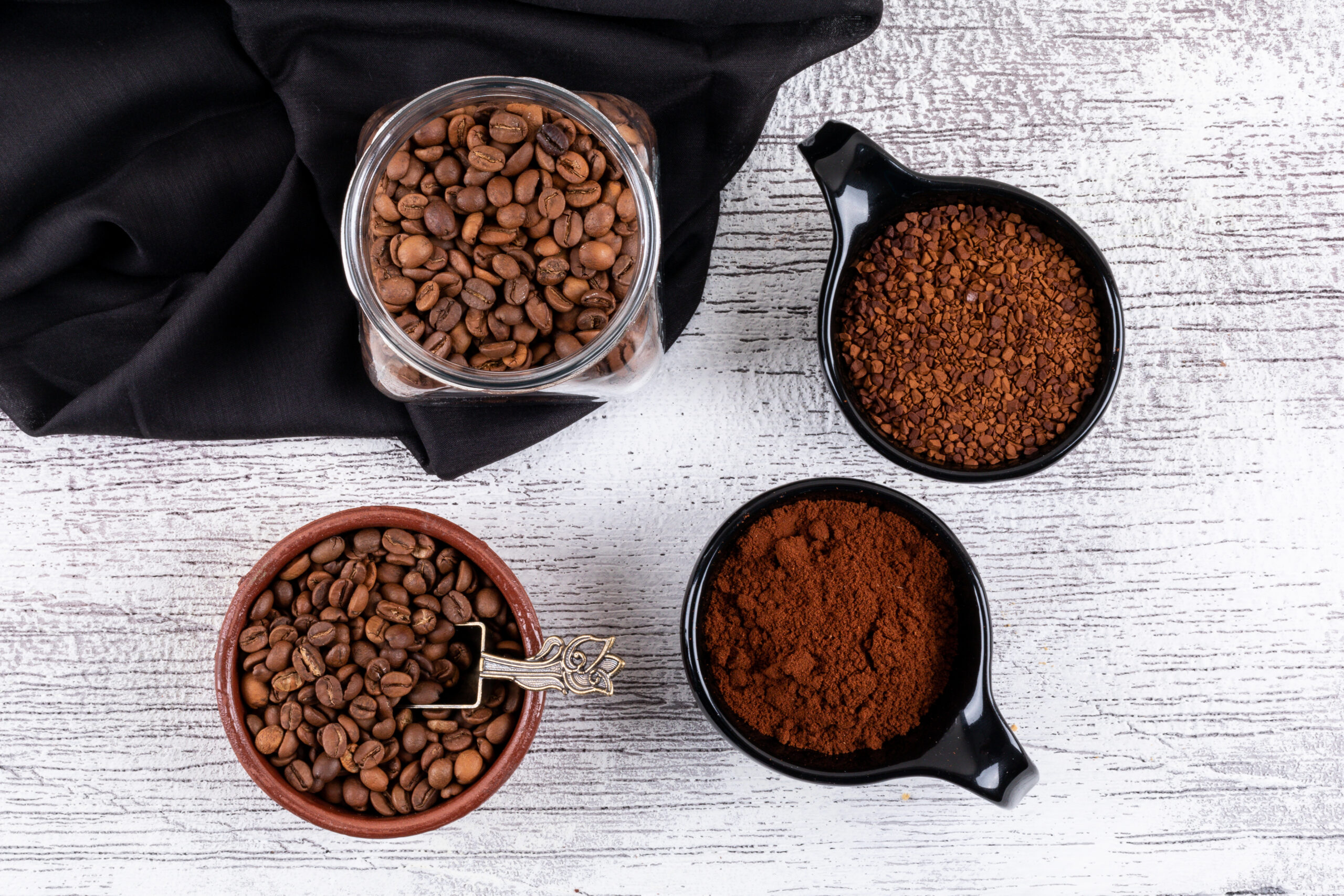top view coffee beans and instant coffee in cups on white table